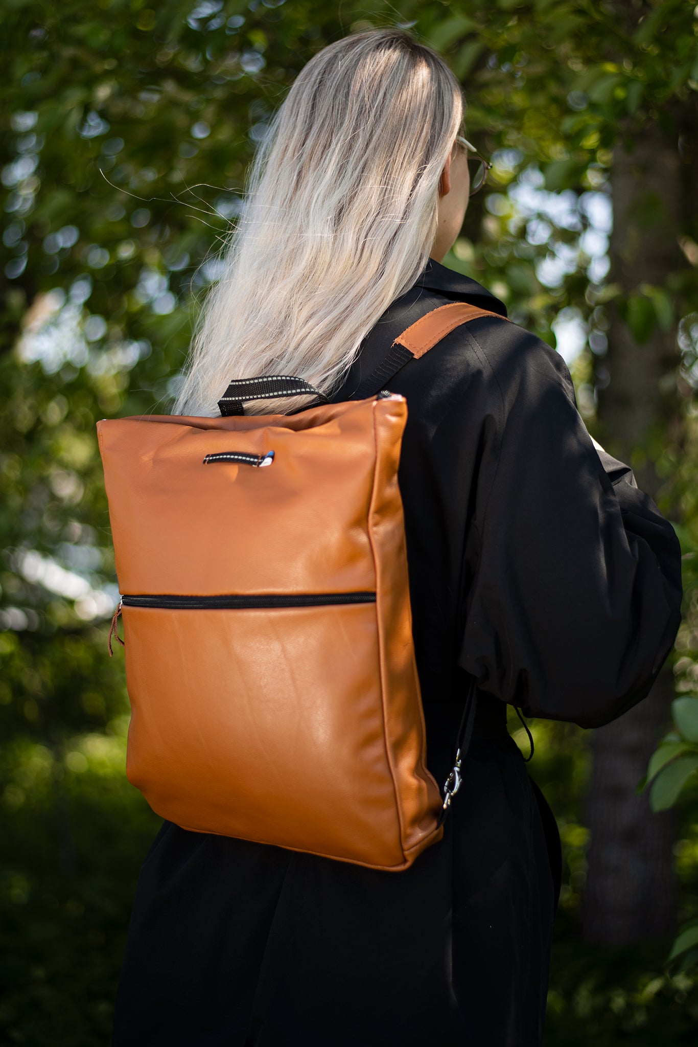 Calvados brown leather backpack by Trendbag worn by person outdoors with greenery background
