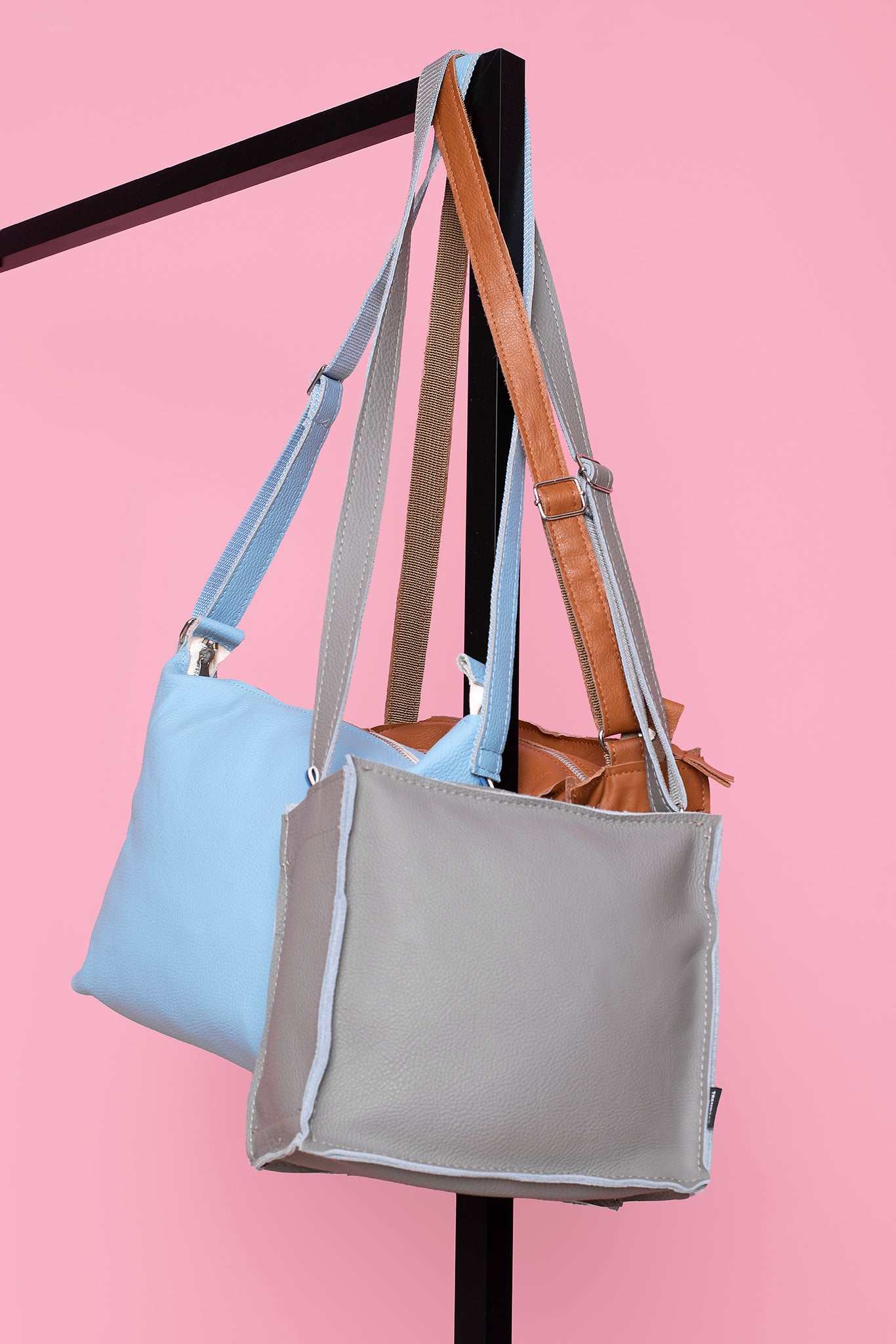 Trendbag light grey shoulder bag with adjustable strap hanging on display stand