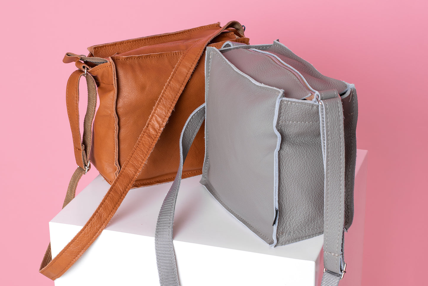 Light grey shoulder bag from Trendbag displayed next to a brown shoulder bag on white pedestal