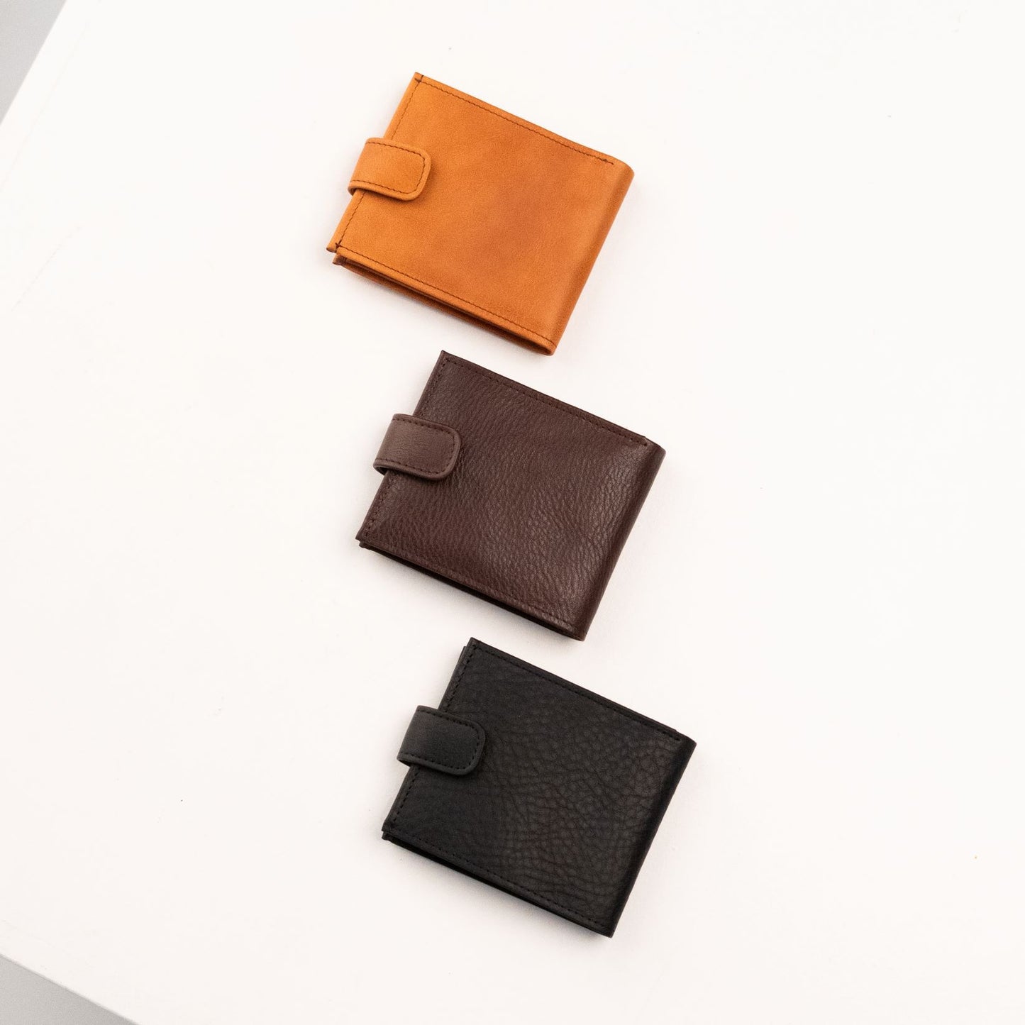 Papillon men's leather wallet in tan, brown, and black with snap closure on white background