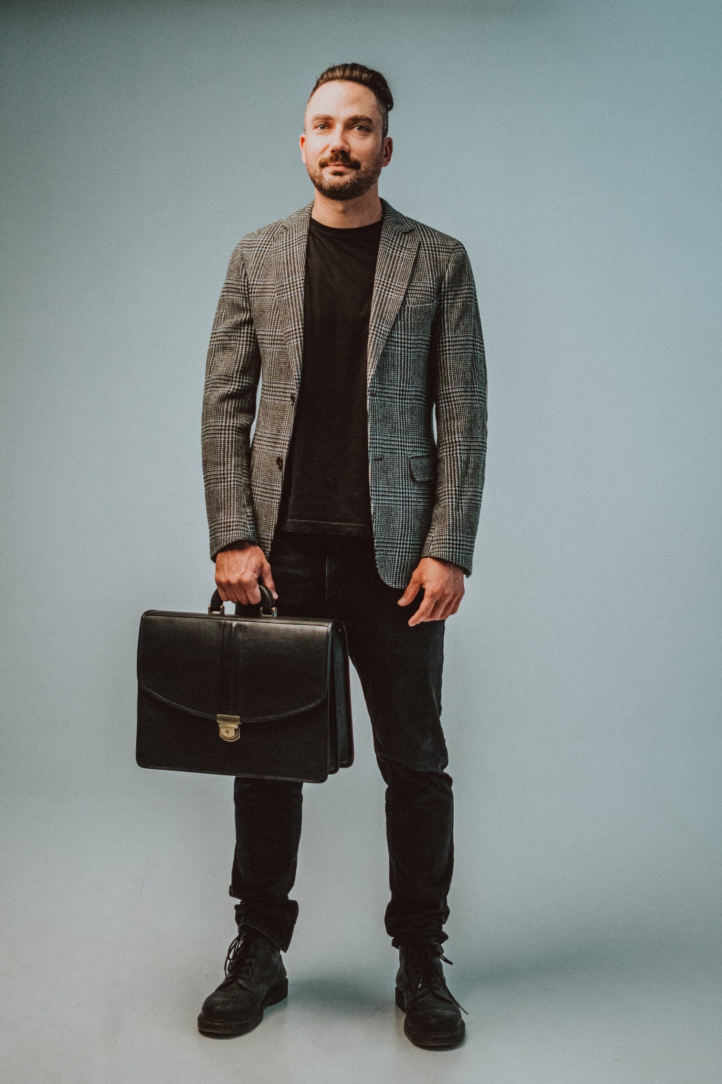 Man wearing a gray blazer holding a professional leather laptop briefcase by Papillon