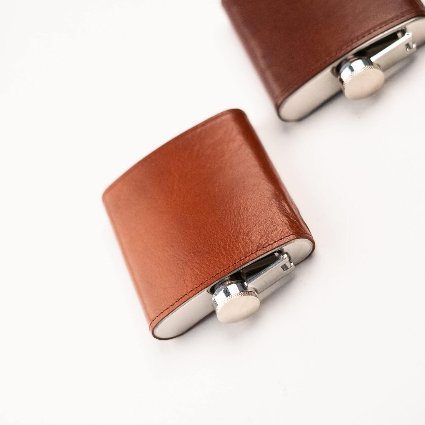 Papillon stylish pocket flask with brown leather cover and stainless steel cap on white background