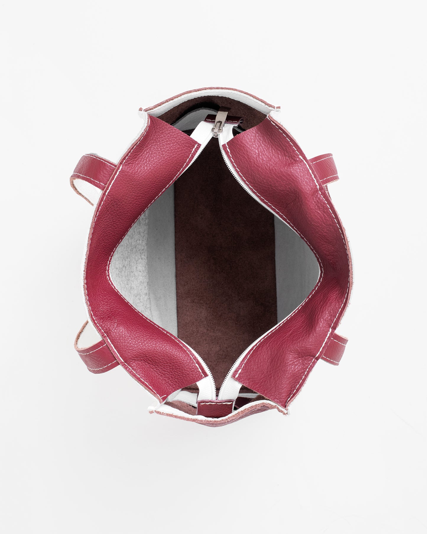 Top view of the inside of a white leather tote bag with maroon interior and handles by Trendbag