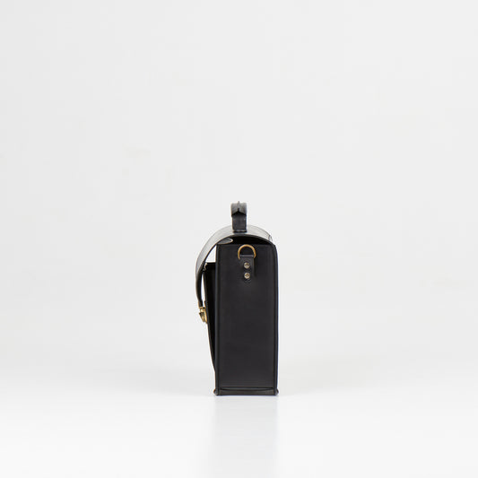 Side view of Papillon artisan leather business bag in black with metal hardware and shoulder strap