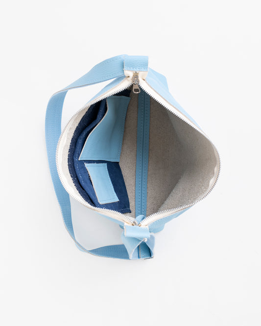 Open light blue shoulder bag showing inner compartments and zippered pocket by Trendbag