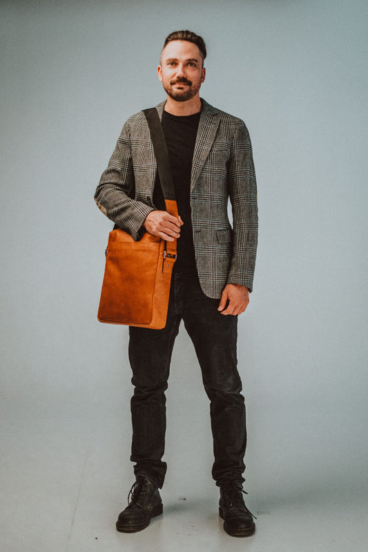 Papillon mens crossbody office bag in brown leather worn by man with blazer and black pants