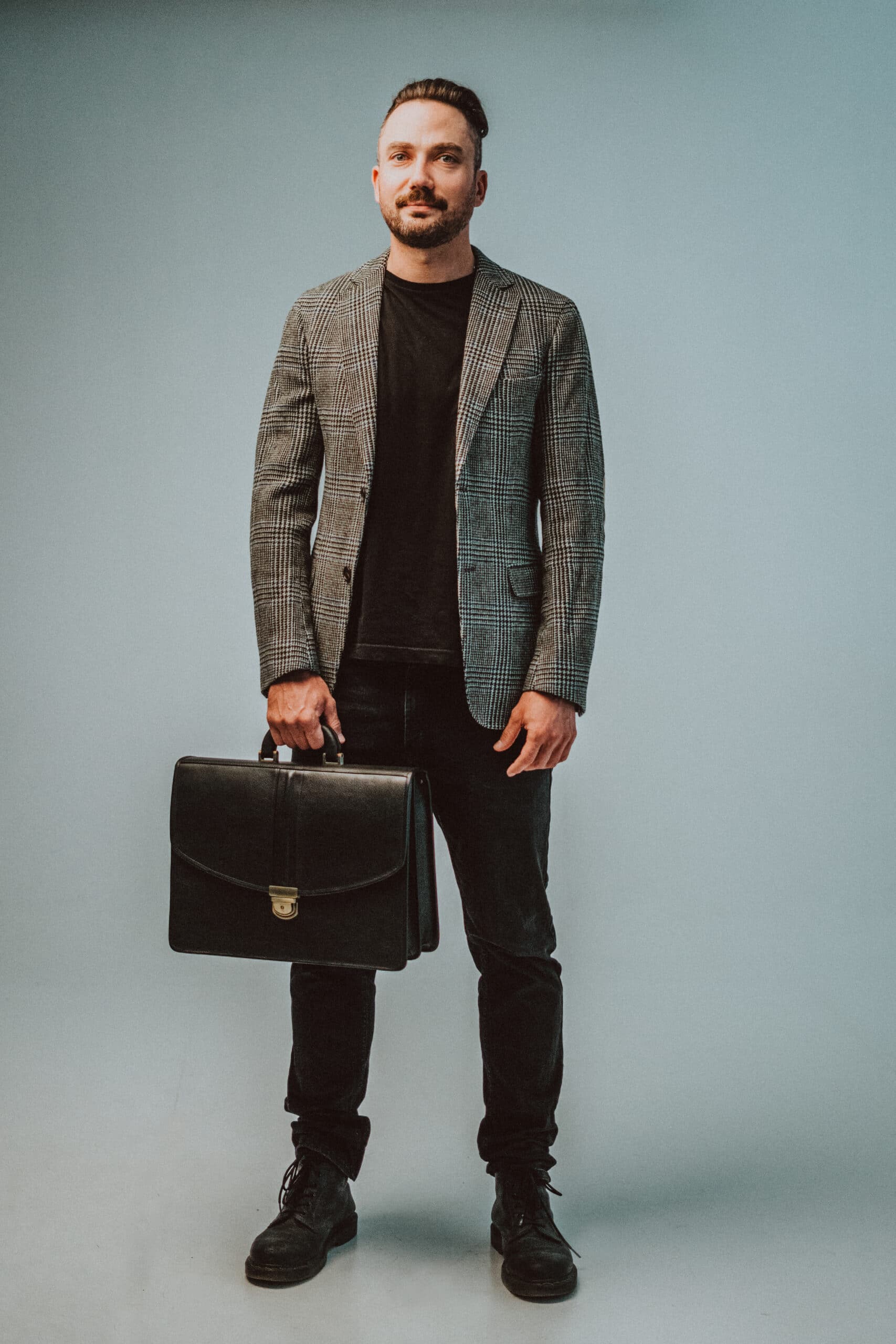 Man wearing a gray blazer holding a professional leather laptop briefcase by Papillon