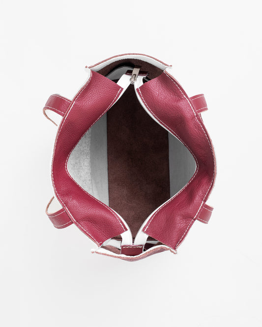 Top view of the inside of a white leather tote bag with maroon interior and handles by Trendbag